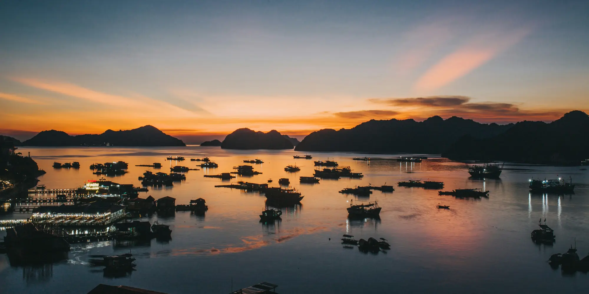 Bucear con tiburones en Vietnam, vista al mar al atardecer con velas y barcos