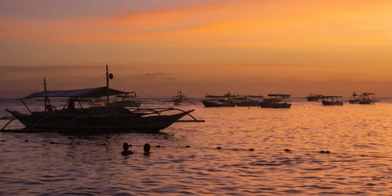 Barcos pesqueros en el mar al atardecer frente a Bohol, Filipinas
