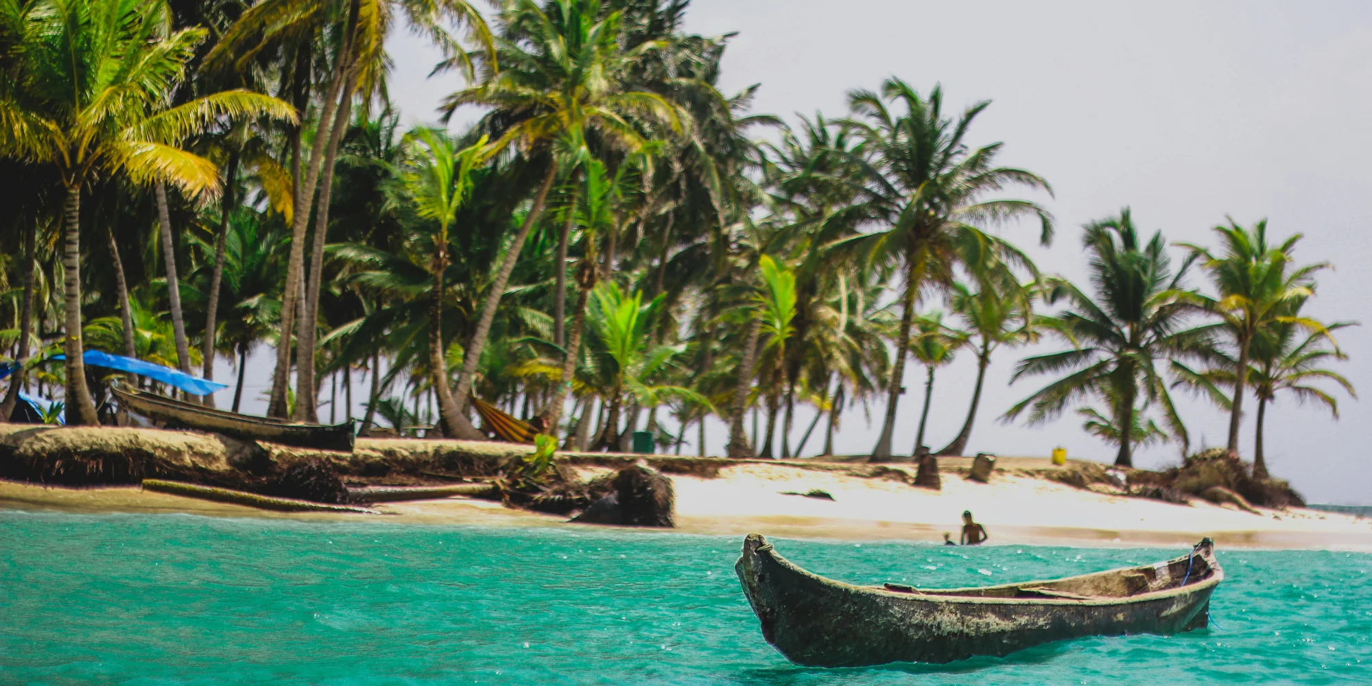 Buceo con Tiburones en Panamá – Playa con Palmeras y Canoa