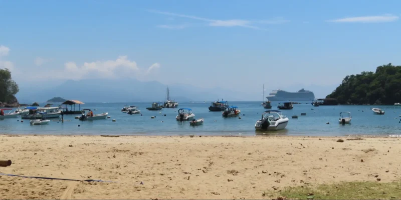 Vista desde una playa de Ilha Grande con barcos y un crucero