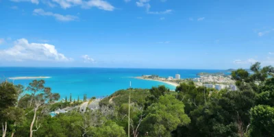 Vista desde una colina arbolada sobre la bahía turquesa y la ciudad de Numea
