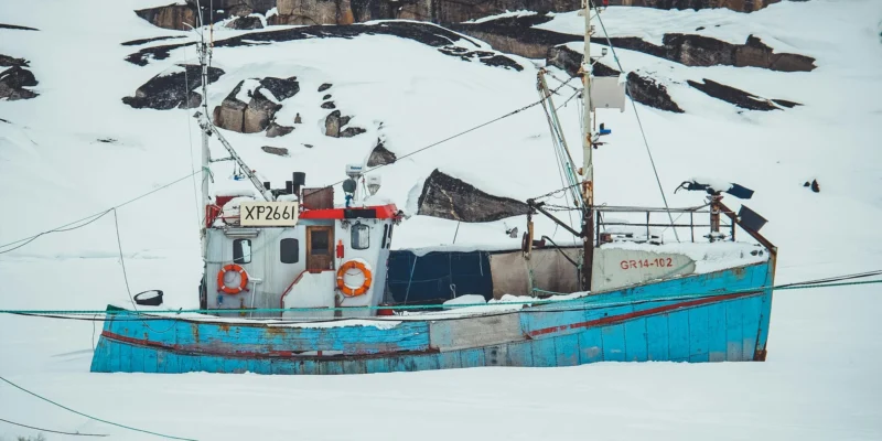 Barco pesquero en un paisaje polar cubierto de nieve